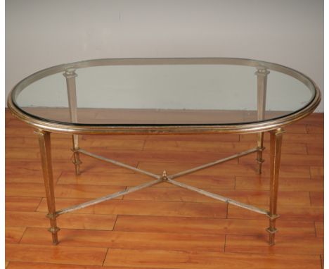 Refined oval cocktail table featuring a beveled glass top set into a gilt iron frame with understated neoclassical styling. T