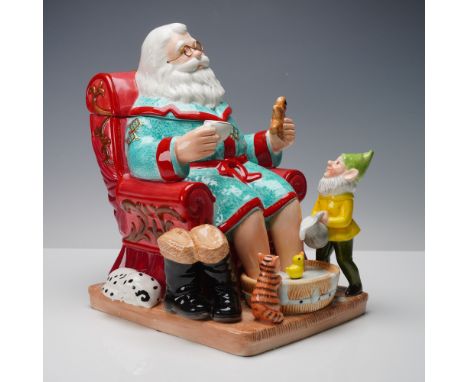 The figural design features Santa Claus seated in a red armchair, dressed in a turquoise robe with red trim and gold detailin