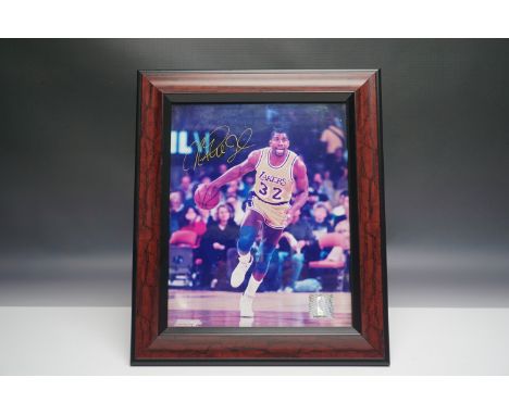 A framed photograph featuring Magic Johnson in action during his time with the Los Angeles Lakers, wearing jersey number 32. 