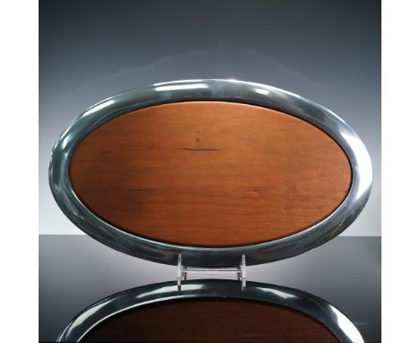 A striking example of modern design and functional elegance, this 19-inch Nambe oval serving platter seamlessly combines rich
