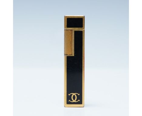 A vintage Cartier butane lighter in a striking black and gold design, housed in its original red Cartier box. The sleek recta