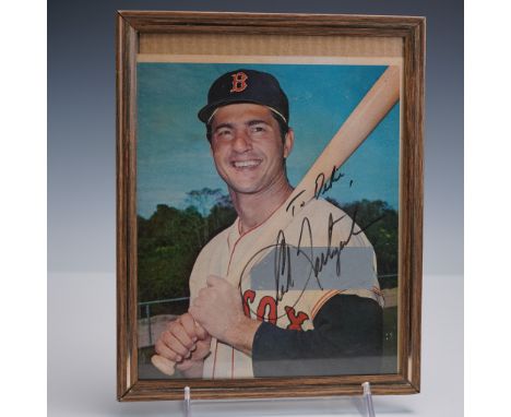 Color photograph of Boston Red Sox Hall of Famer Carl Yastrzemski, captured in uniform and smiling as he poses with a bat. Th