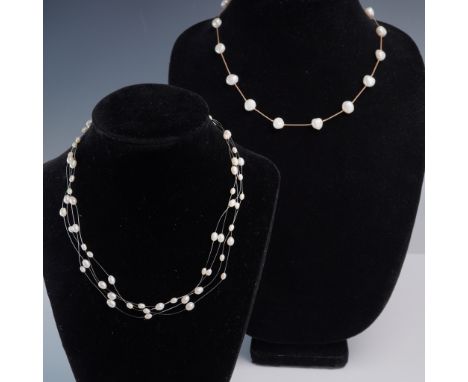 This 2-piece lot includes two elegant freshwater pearl necklaces with distinct styling. The first features four floating stra