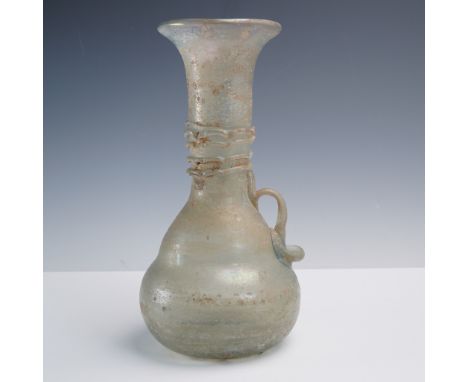 This ancient-style glass vessel features a delicately rounded body, flared neck, and a single applied loop handle. Crafted in