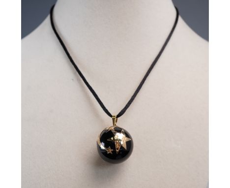 This eye-catching pendant features a polished black onyx orb accented with raised gold-tone star motifs, creating a striking 