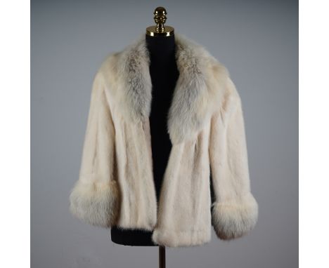 This vintage Younkers genuine fur cape/jacket features a luxurious cream body accented with voluminous fox fur trim at the co