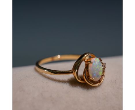 This delicate ring features an oval-cut opal set in 10K yellow gold, marked 10K HK along with partial Roman lettering. The op