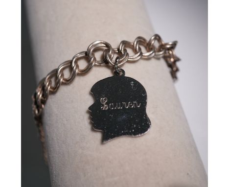 This vintage sterling silver charm bracelet features a chunky curb chain with a silhouette-shaped pendant engraved Lauren. Th