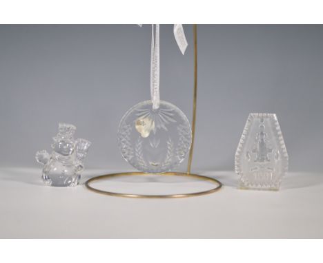 A collection of three Waterford crystal pieces, including two ornaments and one figurine. The round ornament features intrica