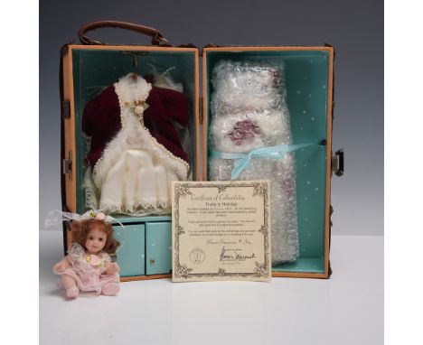 This 2-piece collectible doll lot from Show Stoppers Inc. features the porcelain doll Trudy's Holiday dressed in a white fur-