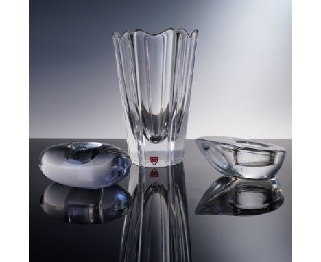 A refined 3-piece collection of modern Swedish crystal by Orrefors, featuring one flared vase and two sculptural votive candl