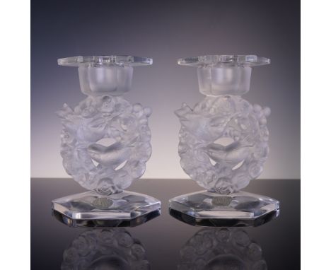 This enchanting pair of Lalique crystal candle holders features frosted crystal birds nestled among blooming floral wreaths. 