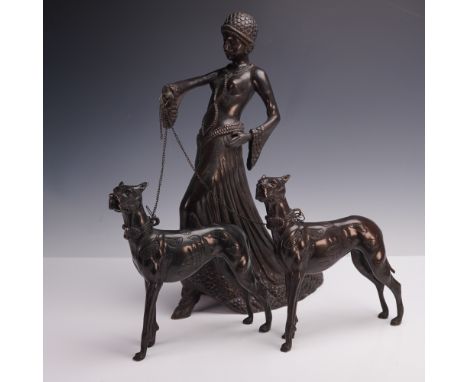A striking three-piece Art Deco-style figural group comprising a stylishly dressed woman holding chains attached to two elega