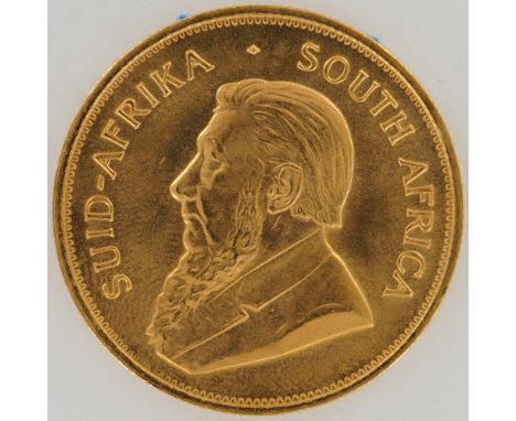 Gold bullion coin from South Africa dated 1984, featuring one troy ounce of fine gold. The obverse side presents a left-facin