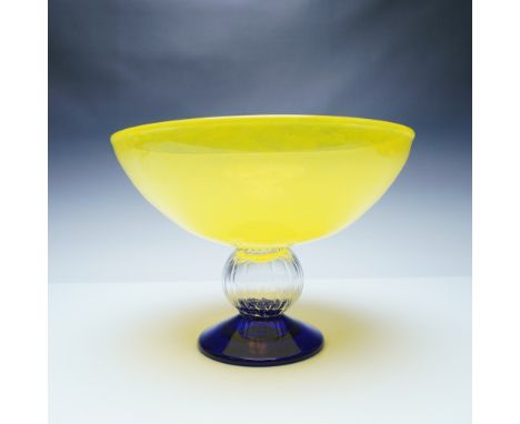 A striking art glass bowl designed by Gunnel Sahlin for Kosta Boda. This sculptural piece features a vibrant yellow bowl cont