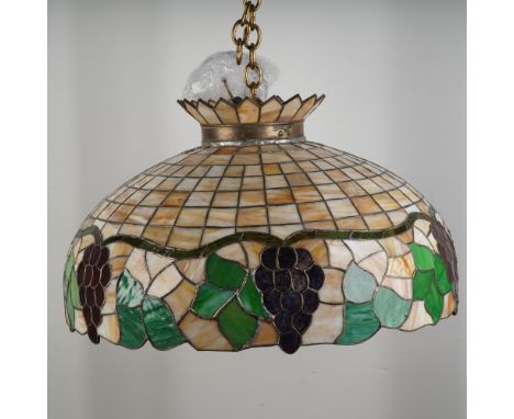 This stained glass ceiling pendant lamp features a dome-shaped shade crafted from richly hued glass panels in amber, green, b