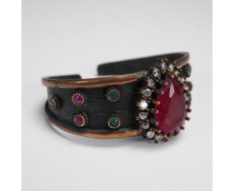 A dramatic vintage-style open cuff bracelet featuring an antiqued copper-tone finish with blackened detailing. The centerpiec