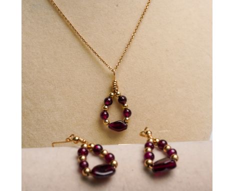 This 3-piece jewelry set features a matching necklace and earring pair composed of deep red garnet beads and gold-toned accen