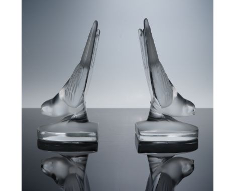 A charming pair of Lalique clear crystal bookends modeled as stylized sparrows with raised wings, capturing a sense of poised