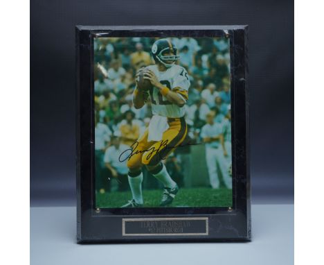 A signed photograph of legendary Pittsburgh Steelers quarterback Terry Bradshaw, featuring him in action during his celebrate