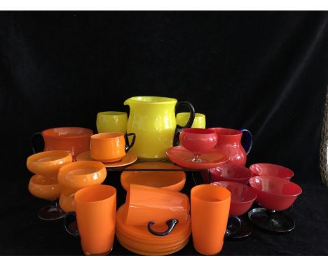 Monochrome Glass - Three water jugs, one orange, one yellow, each with black glass handle; one further jug, red with blue han