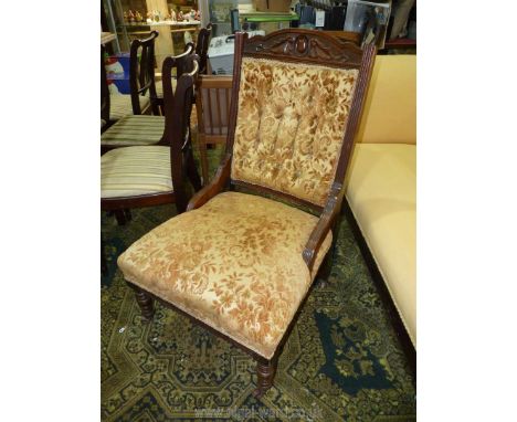 A dark Mahogany framed button backed Edwardian fireside Chair upholstered in stylised floral pattern fabric.