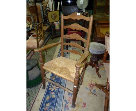 A rustic Ash and other woods ladder-back open armed Elbow chair having a woven seagrass seat (one cross splat repaired)