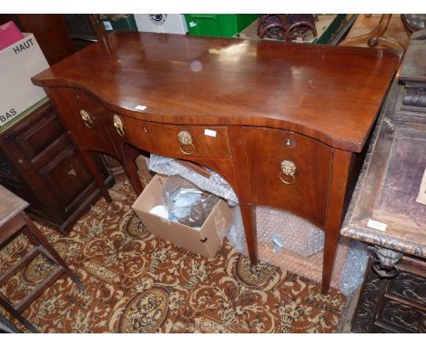 A 19th c. serpentine fronted Mahogany Sideboard having a central frieze drawer flanked to either side by a deep drawer, that 