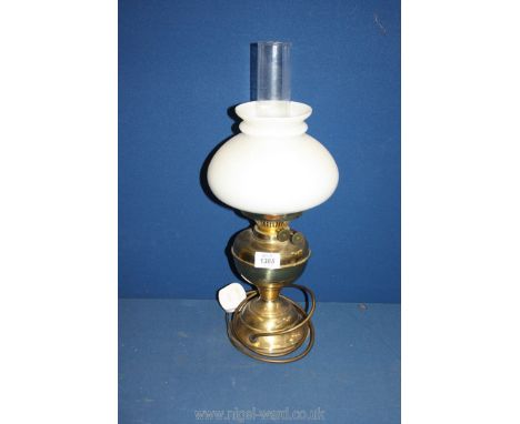 An oil lamp with brass base, white shade and clear chimney, converted to electric, 19" tall.