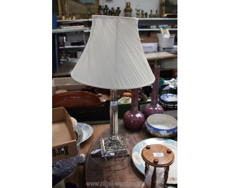 A white metal high gloss finish table lamp in the form of a Corinthian column with base decorated with swags and garlands, 17