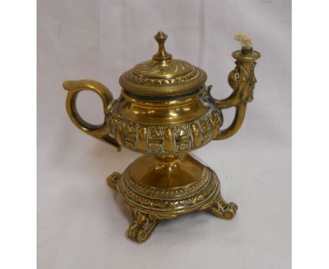 A Victorian cast brass table cigar lighter of antique lamp style with wicked spout and central pull out lighter