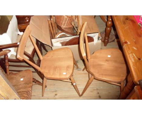 A pair of vintage Ercol light elm kitchen chairs with curved top rails, set on simple turned supports