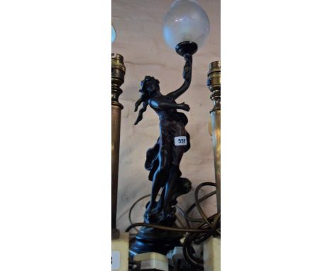 A modern cast resin table lamp in the form of a classical maiden holding a torch aloft with bronzed and patina finish, set on