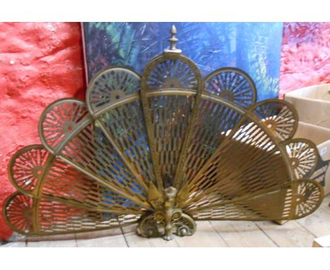 A brass fan shaped expanding fire screen