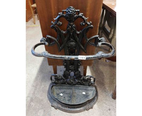 An old Victorian cast iron stick stand of bow top form with original drip tray