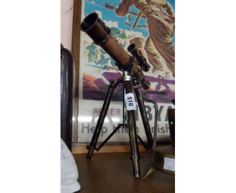 A modern brass desk telescope on tripod stand