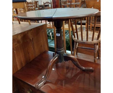A 65cm diameter Georgian oak tilt-top table, set on turned pillar and tripod base with pad feet