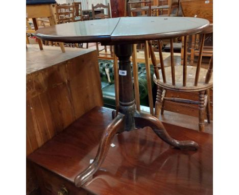 A 65cm diameter Georgian oak tilt-top table, set on turned pillar and tripod base with pad feet