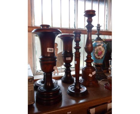 A large turned walnut candlestick with drip sconce - sold with a smaller similar and acanthus leaf decorated turned walnut wi