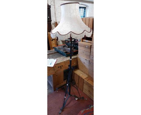 A Victorian painted wrought-iron telescopic lamp standard (converted to electricity) with shade and ornate triple scroll base