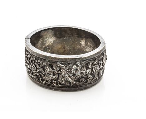 A 19th Century Indian white metal bangle, the floral chased decoration with central hinge and box clasp, 5.6cm x 5cm, 79g 