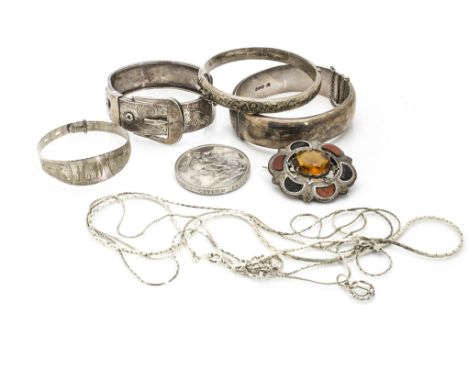 A collection of Victorian and later silver jewellery, including a belt buckle bangle, three other bangles, a white metal Scot