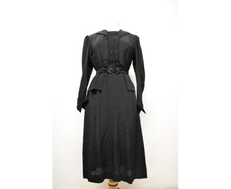 A 1930s black dress having peplum waist, gathered bodice with ladder work to front panel and collar, full length sleeves and 