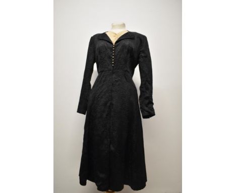 A stunning late 1920s/ 1930s black dress having deeply textured floral pattern, filigree metal buttons to front and cuffs and