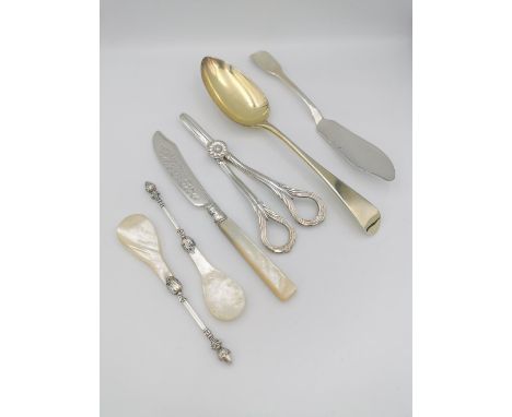 A collection of silver cutlery, including a later gilded Georgian serving spoon, a pair of grape scissors, a butter knife and