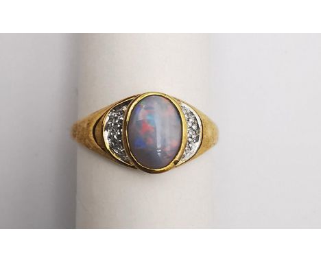 A 9ct opal and diamond flanked solitaire ring. Set to centre with an oval cabochon black opal with an approximate carat weigh