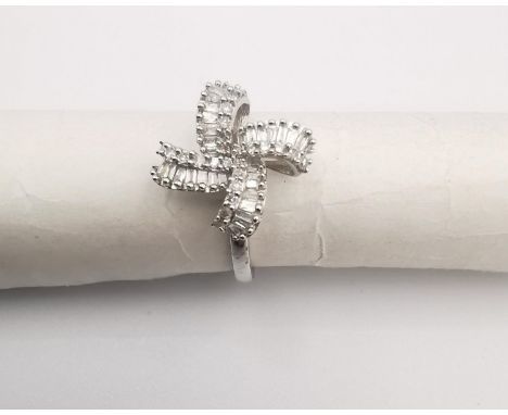 A 9ct white gold diamond set bow design ring , set with twenty eight rectangular baguette cut diamonds with a combined approx