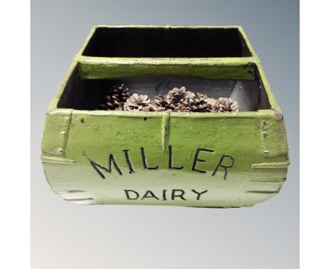A Miller Dairy caddy containing pine cones 