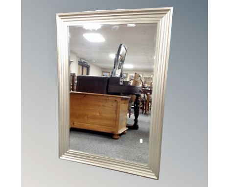 A bevelled mirror in a silvered step frame 