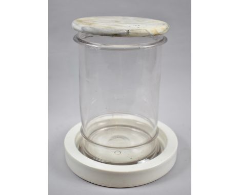 An Unusual Counter Top Cylindrical Glass Shop Jar on Circular Ceramic Base and with Marble Cover, 30cm high 